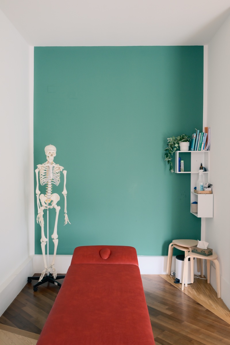 Therapieraum mit Behandlungsliege und anatomischem Skelett